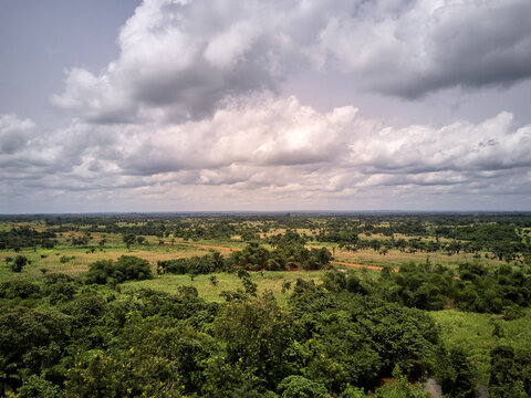 Benin, Large white clouds over green African landscape