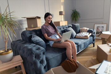 Happy woman using computer in a new apartment.