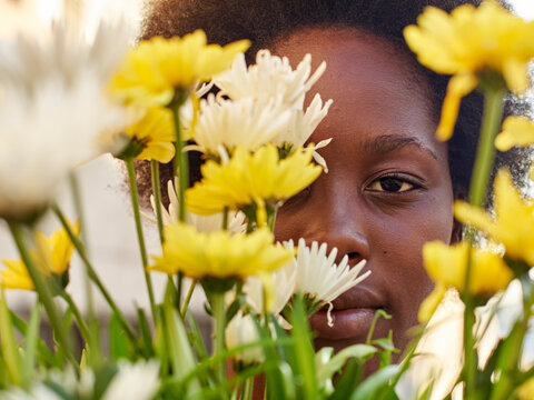 Woman hiding behind flowers