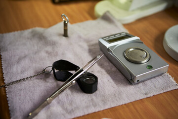 Diamond ring, amplifying glass and tweezers holding a diamond