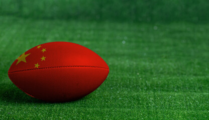 American football ball  with China flag on green grass background, close up