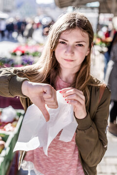Girl with plastic bag showing thumb down