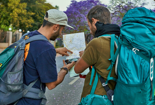 Two backpackers checking a map on a street