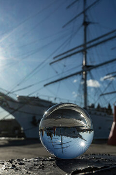 Germany, Mecklenburg-West Pomerania, Stralsund, Gorch Fock sailing ship reflecting in shiny glass ball