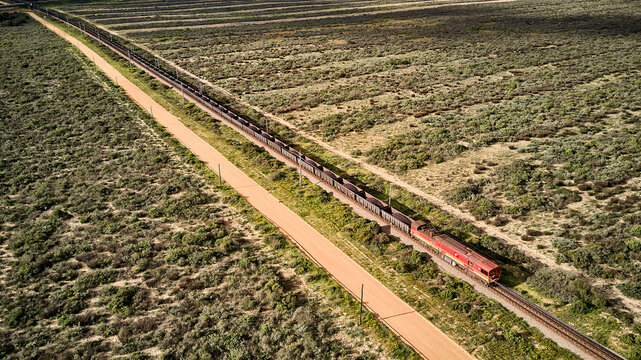 South Africa, Western Cape, Aerial view of cargo train passing by fields