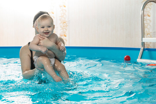 Baby swimming, mother with daughter in swimming pool