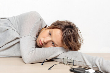 Portrait of sad young woman lying on the floor