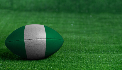 American football ball  with Nigeria flag on green grass background, close up