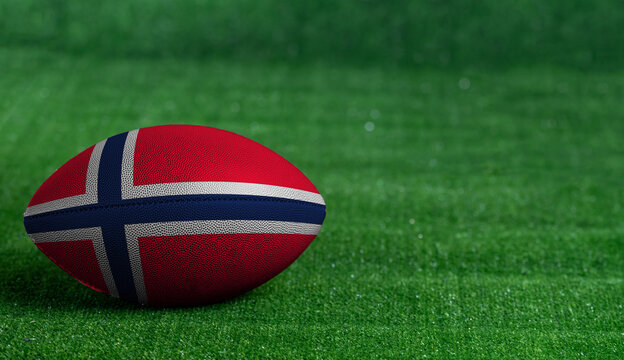 American football ball  with Norway flag on green grass background, close up