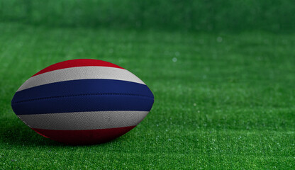 Fototapeta na wymiar American football ball with Thailand flag on green grass background, close up