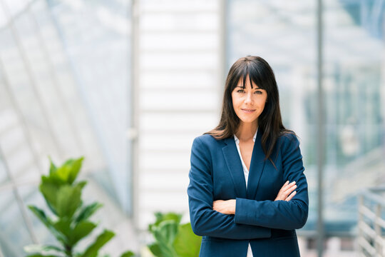 Confident businesswoman with arms crossed at office