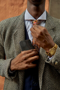 Close-up of stylish young businessman fixing his tie