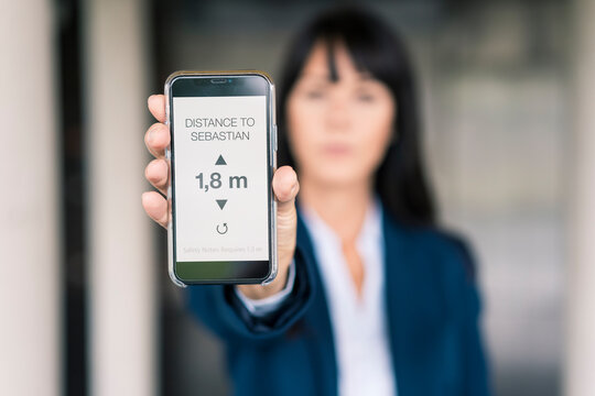 Female entrepreneur showing direction on map through smart phone