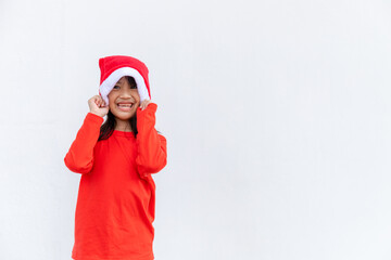 Asian little girl in red Santa hat on white background.