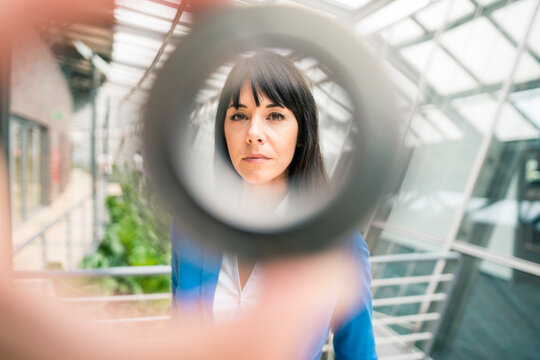 Businesswoman seen through equipment in office corridor