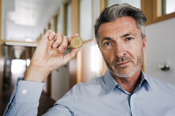 Businessman holding bitcoin in hand at office