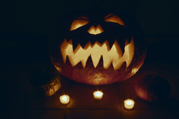 Zucca di Halloween intagliata con un viso horror e illuminata da candele