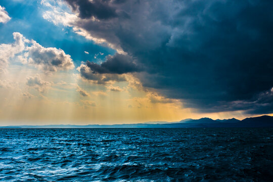 Italy, Province of Verona, Lazise, Gray storm clouds floating over Lake Garda at dusk