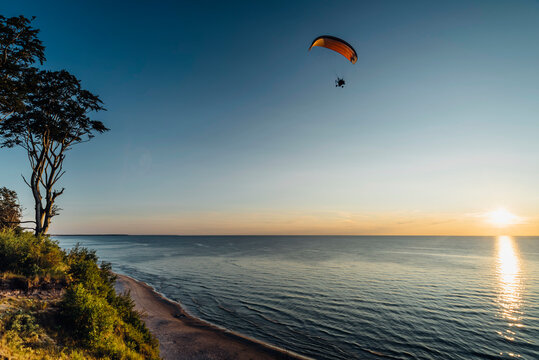 Paragliding over sea in Poland against clear sky