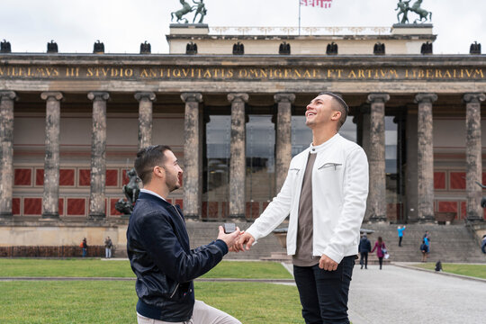 Young man proposing to his surprised boyfriend at Lustgarten, Berlin, Germany