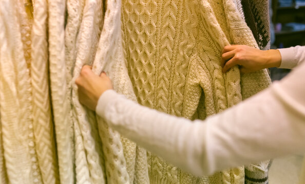 Close-up of woman shopping for a pullover in a vintage boutique