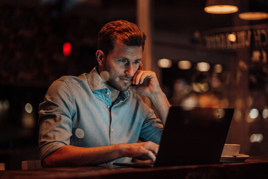 Businessman using laptop while sitting at cafe
