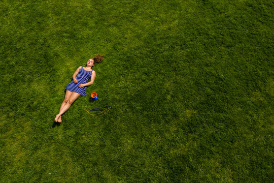 Aerial view of a young woman lying on a meadow