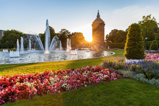 Germany, Mannheim, Friedrichsplatz with fountain and water tower in the background by sunset