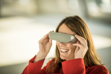 Smiling businesswoman looking through VR goggles