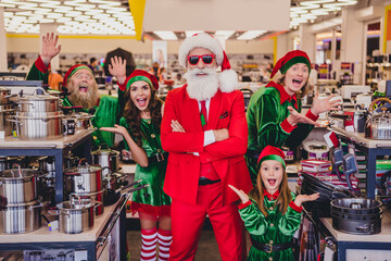 Portrait of attractive cheerful funky company elfs buying goods having fun advent bargain opening December at mall store indoors