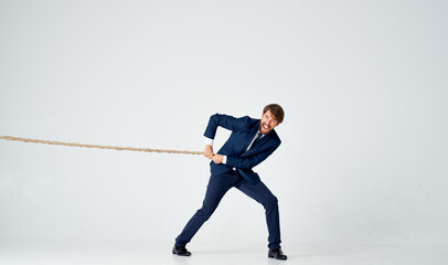 business man in a suit with a rope in his hands manager office light background