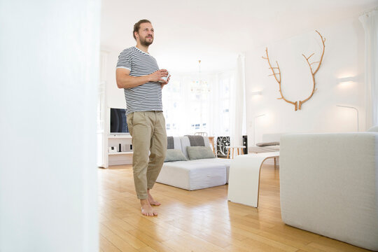 Young man with cup of coffee at home