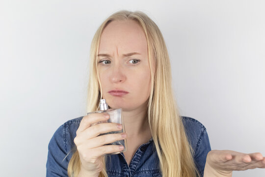 Loss of smell. Girl in front of the mirror sniffs the perfume and realizes that she does not feel it. Self-diagnosis covid-19. Symptoms of coronavirus. Quarantine and isolation. Test for sars-cov-2