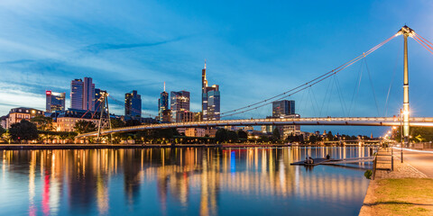 Illuminated Holbeinsteg footbridge over river at night in Frankfurt, Germany