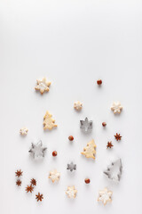 Christmas composition is made of Christmas cookies, cookie cutters, nuts and anice stars on white background. Copy space.
