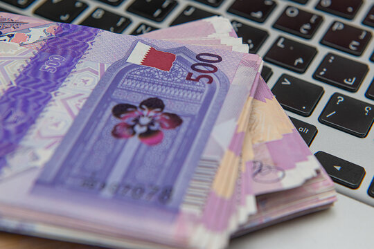 Bitcoin Cryptocurrency on Qatari 500 Riyal banknotes. Selective focus. business and Finance 