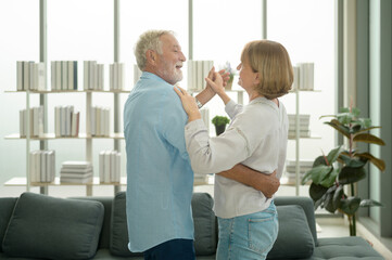 Obraz premium Happy Caucasian senior couple dancing at home