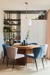 Stylish elegant dining room interior design composition with velvet armchairs, design rouded wooden...