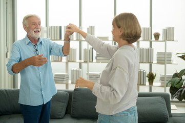 Obraz premium Happy Caucasian senior couple dancing at home