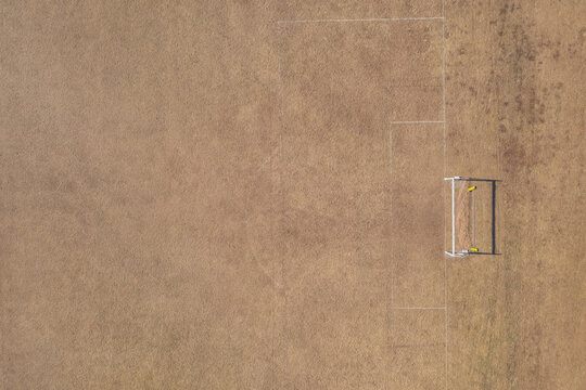Aerial view of goal post on dry soccer field in summer during drought