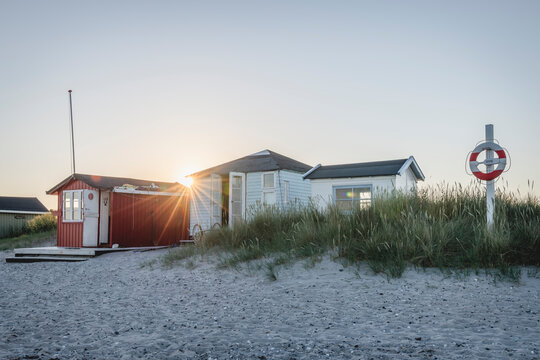 Denmark, Region of Southern Denmark, Marstal, Life belt hanging in front of beachside bathhouses at sunset