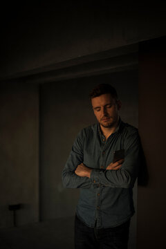 Exhausted businessman leaning on wall, with arms crossed