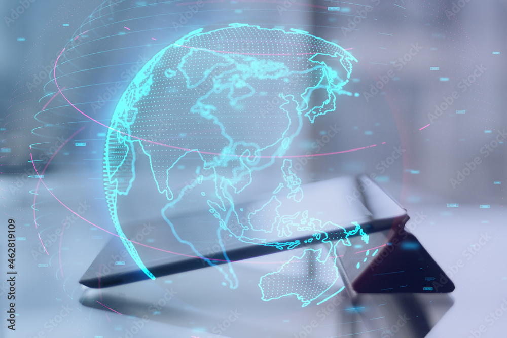 Poster close up of tablet on desktop with glowing digital blue globe hologram on blurry background. interne
