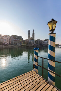 Switzerland, Canton of Zurich, Zurich, Jetty on bank of Limmat river with Grossmunster and waterfront buildings in background