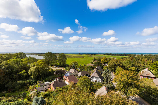 Germany, Mecklenburg-Western Pomerania, Wustrow, Summer clouds over town surrounded by green trees