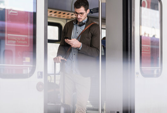 Young man using cell phone in commuter train