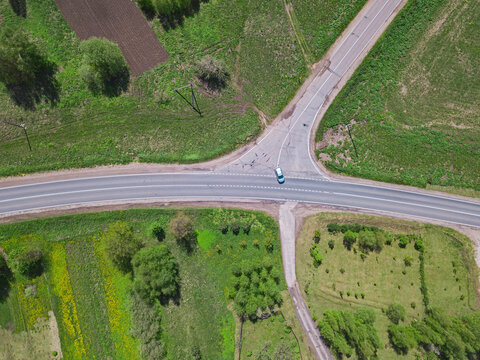 Russia, Moscow Oblast, Aerial View Of Car Driving Past Intersection On Country Road