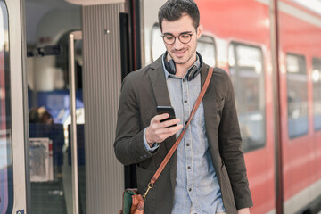 Young man using cell phone at commuter train