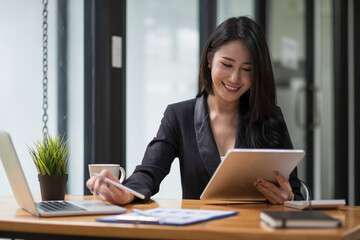 shot of business woman working for financial accounting with laptop and digital tablet