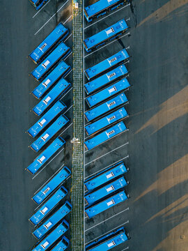 Aerial view of parking lot filled with blue buses